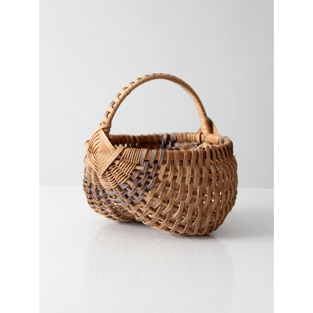 This vintage buttocks basket, also known as a melon basket, features an intricate handwoven wicker design with contrasting...