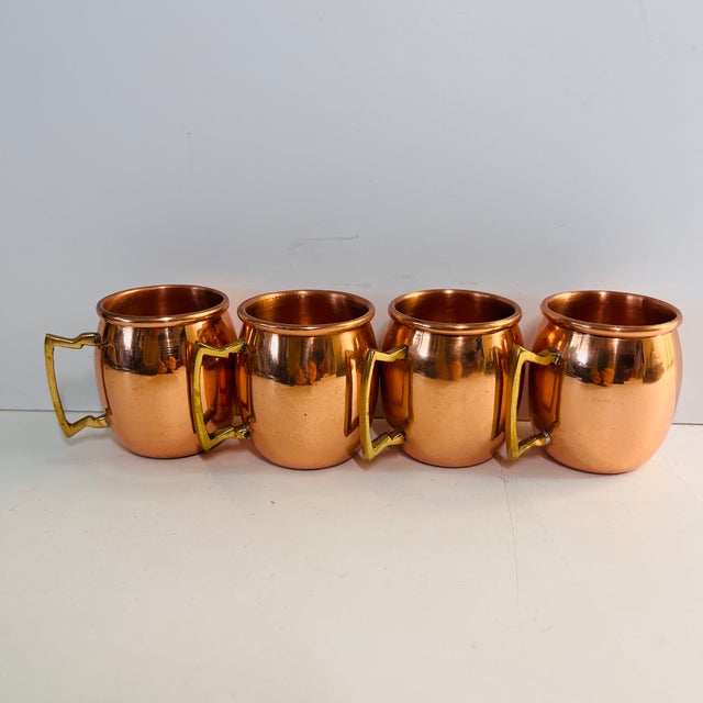 Charming set of four miniature copper Moscow Mule shot mugs. Brass handles. Light wear.