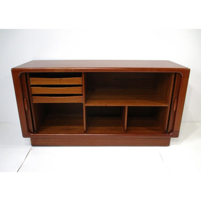 A very well-crafted teak wood credenza with unique double tambor doors having long nicely shaped handles. Inside there are...