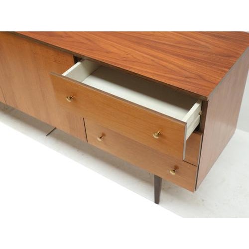 Vintage sideboard with 3 doors and drawers made in the 1960s. This vintage sideboard from the 1960s combines a sleek...
