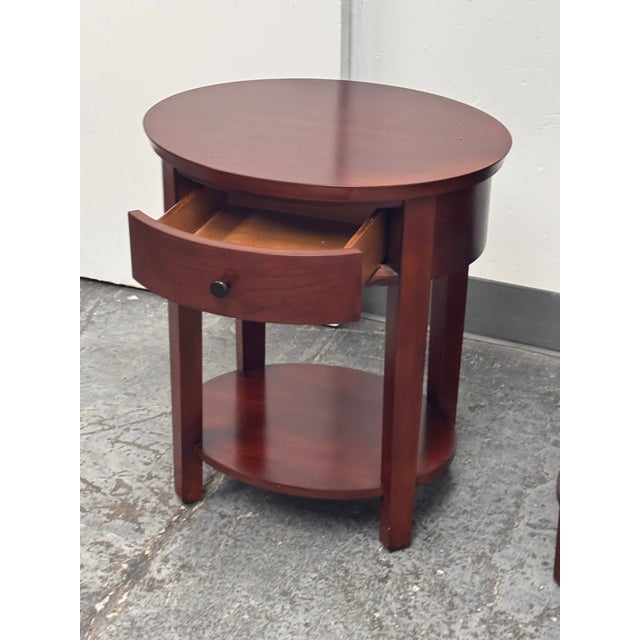 Design Plus Gallery presents a Pair of Valencia Oval Nightstands from Pottery Barn. Each wood nightstand has an oval top,...