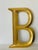 Large gold tone letter B wall decor.