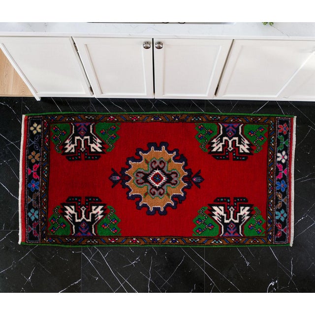 Elevate your living space with this vibrant and authentic vintage Anatolian small rug, featuring a striking red field and...