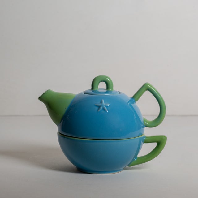 Adorable blue and green tea pot and cup set featuring a small star shape on the front of the tea pot.
