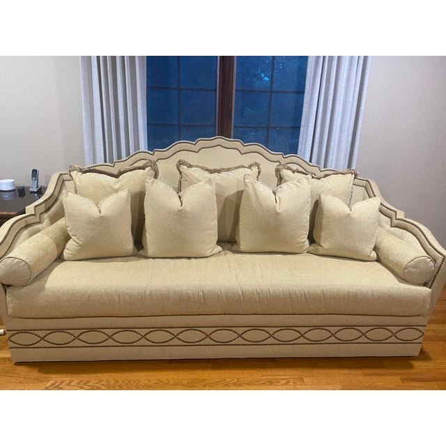 Stunning sofa in gold tone with nailhead trim. Comes with 9 pillows. Large seat base- wide enough to sleep in.