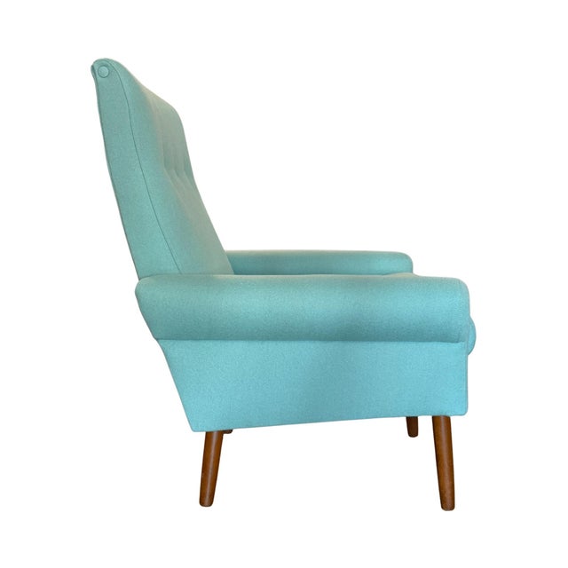 Vintage mid-century Danish modern upholstered lounge chair with teak legs. This restored 1960s classic features brand new...