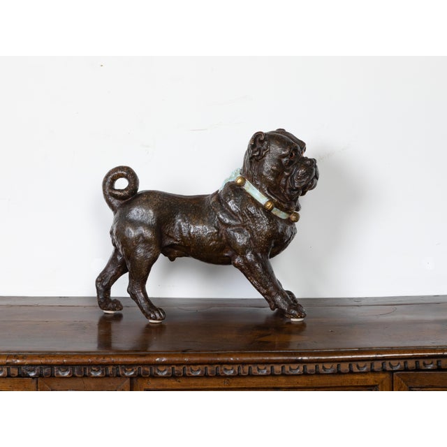 An English terracotta standing dog sculpture from the early 20th century, with glass eyes, green collar and bells. Created...