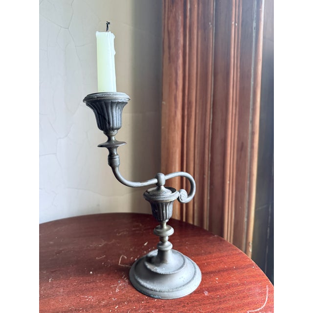 Early 20th Century pewter candlestick holder with asymmetrical swooping form and weighted base for stability. Warm aged...