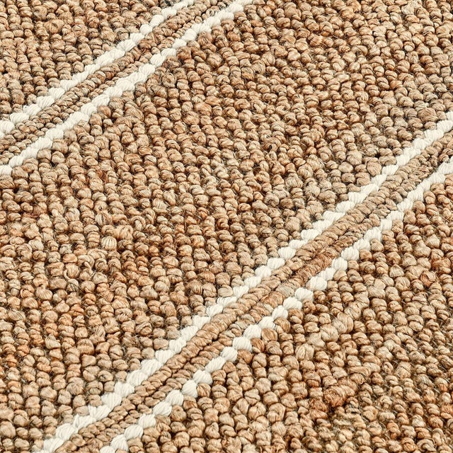 Hand woven natural jute rug with ivory striped detail. Please note that its appearance may vary depending on lighting...