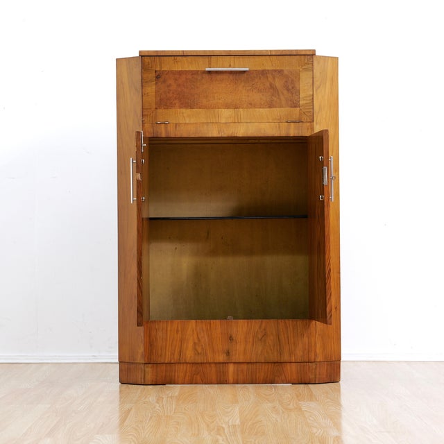 This is a fantastic 1950s English walnut and burl cocktail cabinet. The upper front cabinet door pulls open revealing a...