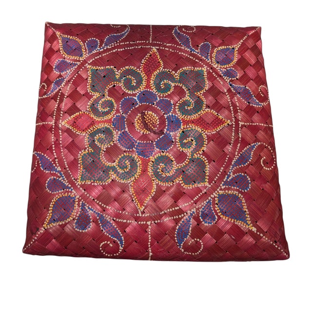 This high-quality, square woven basket features a unique hand-painted geometric and floral motif. The artistry on the lid...