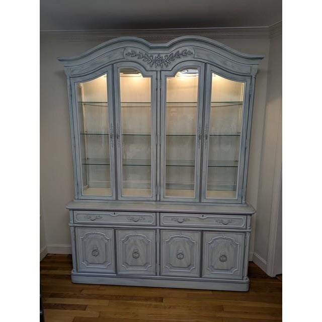 An exceptional high-end china cabinet by Thomasville, crafted in the timeless French Country style. This beautifully...