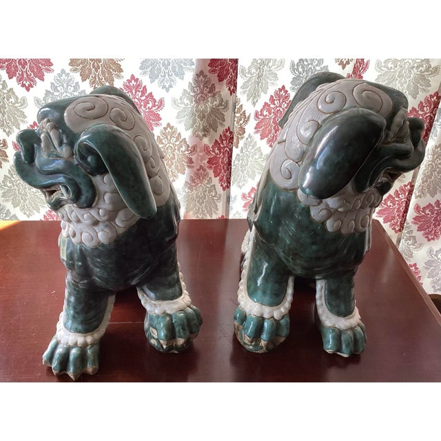 A striking pair of large, antique Chinese guardian lions (commonly known as Foo Dogs), crafted in richly glazed emerald...