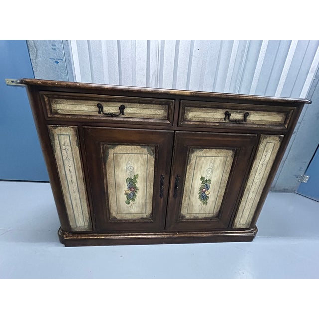 A distinctive Drexel Heritage French Accents buffet/sideboard, featuring a richly toned walnut finish contrasted by...