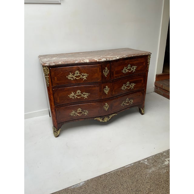 French Regence Marble Top Serpentine Fronted Commode. Kingwood and Tulip Parquetry. Gilt Bronze Hardware. Stamped I.M....