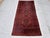 This antique hand-knotted Baluch rug features three stacked diamond medallions in deep navy and rust, each centered with a...