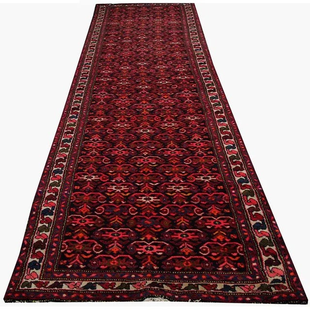 Handwoven Vintage Persian Hamedan rug on a navy colored field and ivory border accented in shades of green, rust, light...