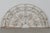 A 19th century French salvaged architectural demilune cast iron grille. White painted patina with some paint loss and...