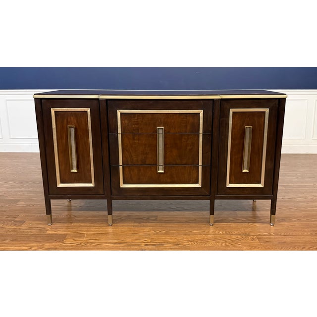 This is the Lyric Mahogany Credenza/Dresser by Maitland - Smith. It has three soft-close drawers and two doors with...