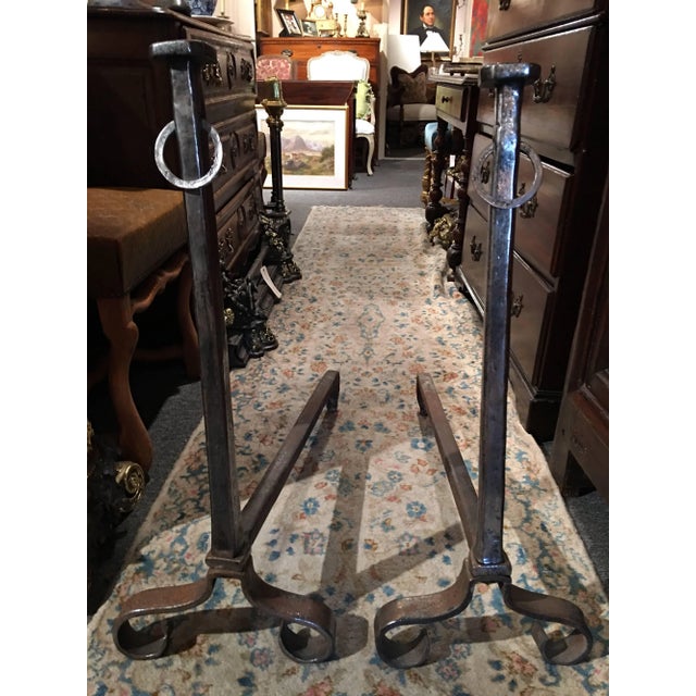 Pair of iron chenets or andirons with a decorative ring, 19th century.