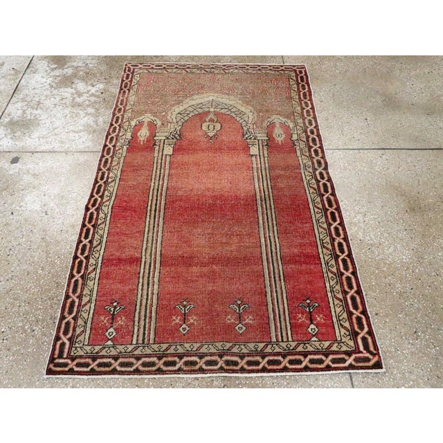 This early 20th century Turkish Oushak rug, is a striking example of the prayer rug tradition, distinguished by its...