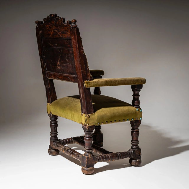 Impressive early Baroque armchair with straight, upholstered armrests, turned baluster legs, and cross stretchers. The...