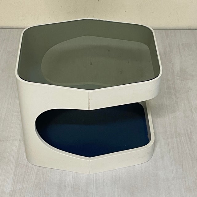 A 1970s-era two-tier coffee table with a hexagonal shape, rounded corners, and a C-shaped frame. The top extends on one...