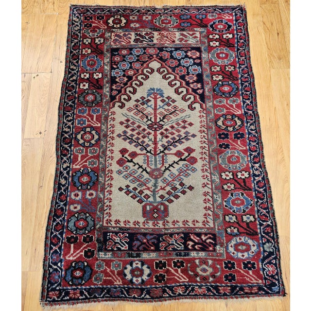 This exquisite antique Anatolian village prayer rug from the early 20th century features a refined Tree of Life...