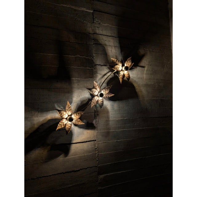 Floral wall lamp designed by Willy Daro made of gold metal and brass in the 70s. Each light point presents beautiful...