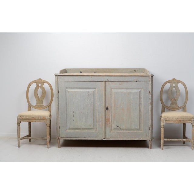 Antique gustavian sideboard from Northern Sweden made around 1780. The sideboard is made in painted pine and dry scraped...