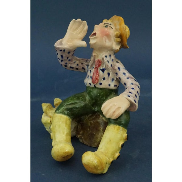 Glazed ceramic sculpture, molded and decorated entirely by hand, depicting a seated vegetable vendor, with the inscription...