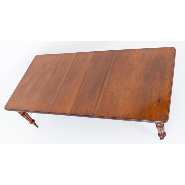 A fine Victorian walnut extending dining table, raised upon elegant turned and fluted legs fitted with brass castors Circa...