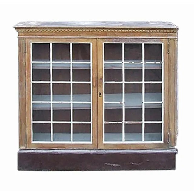 Pair of traditional antique cabinets. Pickled walnut with paned glass doors. Circa 1890.