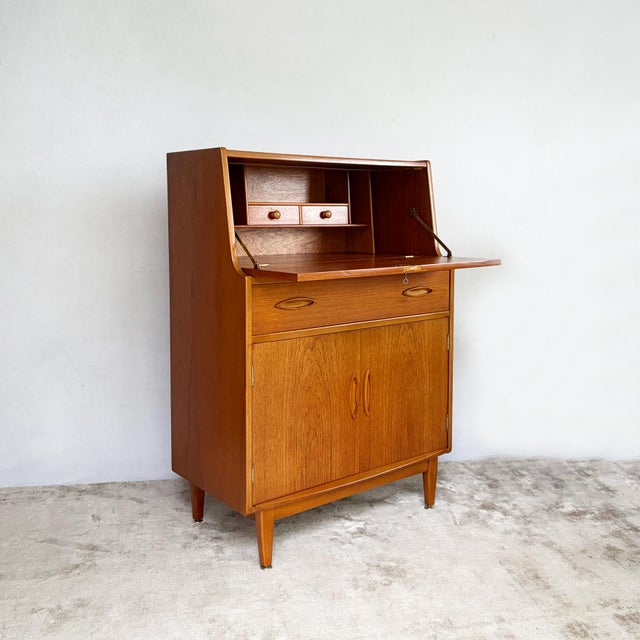A neat, well made teak writing bureau by Jentique, packing a proper desk and plenty of storage into a compact footprint....