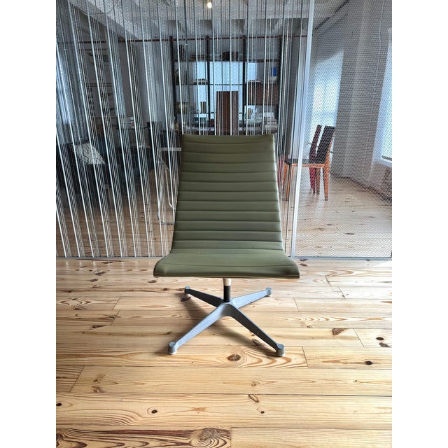 Classic Eames Group lounge chair featuring elegant gray-green upholstery and a timeless mid-century modern design....