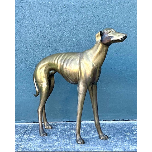 This exceptional vintage monumental greyhound sculpture is a masterful study in movement, balance, and refined form....