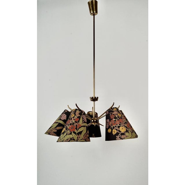 A mid-century brass chandelier with five arms. The shades are the original ones that came with the lamp and are in very...