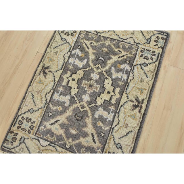 A modern tribal Oushak rug hand-knotted with an all-wool pile on a cotton foundation. This oriental rug features a central...