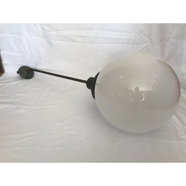 Original 1920's / 1930's School house light fixture. Featuring a round milk glass globe and original patina on mounting...