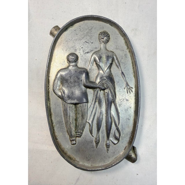 This vintage risque speakeasy double sided figural metal ashtray is a unique and collectible piece that is sure to add a...