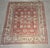 Vintage Oushak-style wool rug featuring a warm salmon field framed by a contrasting ivory border. The open floral...