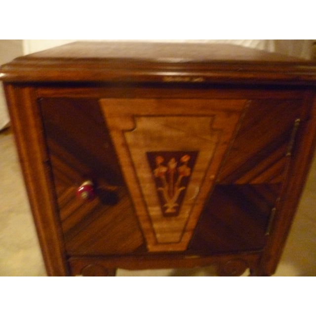 This is a 19th century bed stand. Rich in color tones. Inlaid color flowers in wood . Original door pull in burgundy. One...