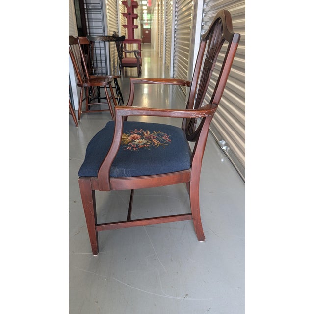 Vintage Hepplewhite style shield-back mahogany armchair featuring floral needlepoint on navy cushion. "Stamp" or tag...