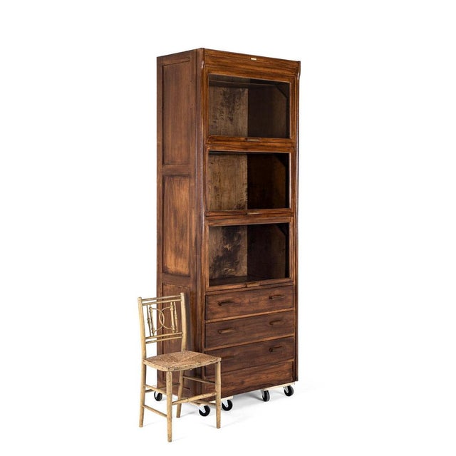 A tall and unusual pine haberdashery cabinet with three deep large glazed retracting shelf compartments on brass runners....