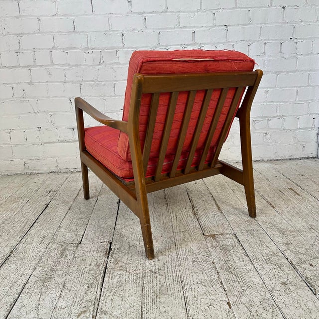 This Danish modern lounge chair has a great angular shape with curved detailing throughout. This chair is currently in red...