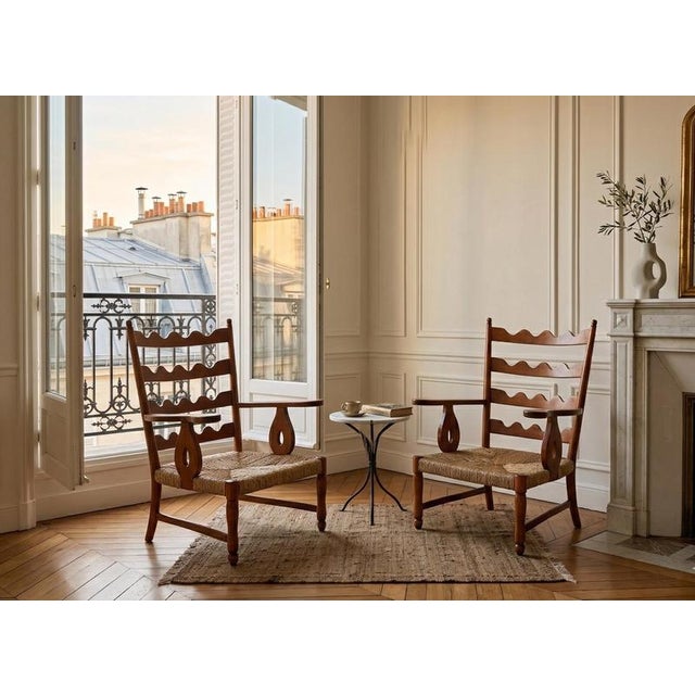 This is a pair of elegant armchairs designed by Paolo Buffa, crafted from solid cherry wood with a warm reddish-brown hue....