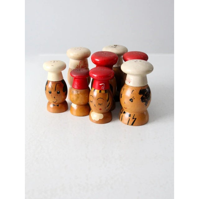 Collection of eight vintage wooden salt and pepper shakers, circa 1950, each hand-painted with playful chef designs. The...