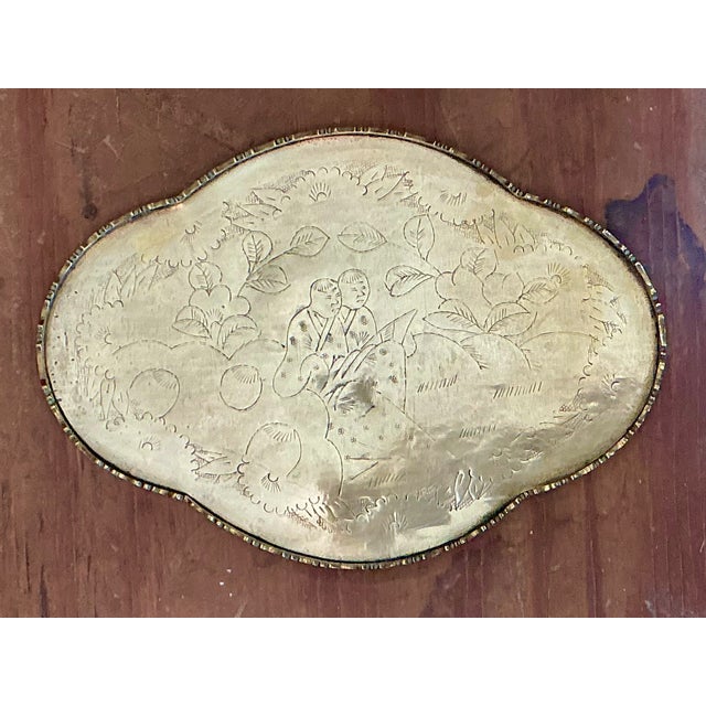 This vintage engraved Chinoiserie brass tray beautifully reflects the enduring elegance of Asian-inspired decorative arts....