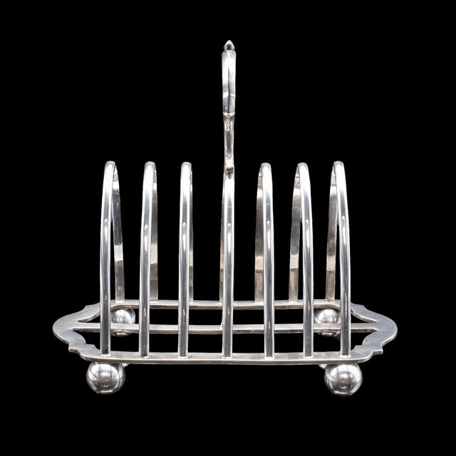 This is an antique toast rack. An English, silver plated breakfast table stand, dating to the Edwardian period, dated...