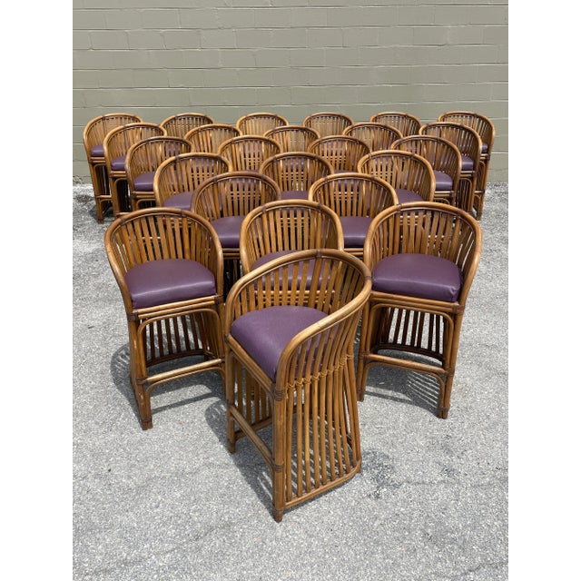24 total chairs, all upholstered in a purple vinyl fabric. The frames are made of bent rattan and a footrest provides...